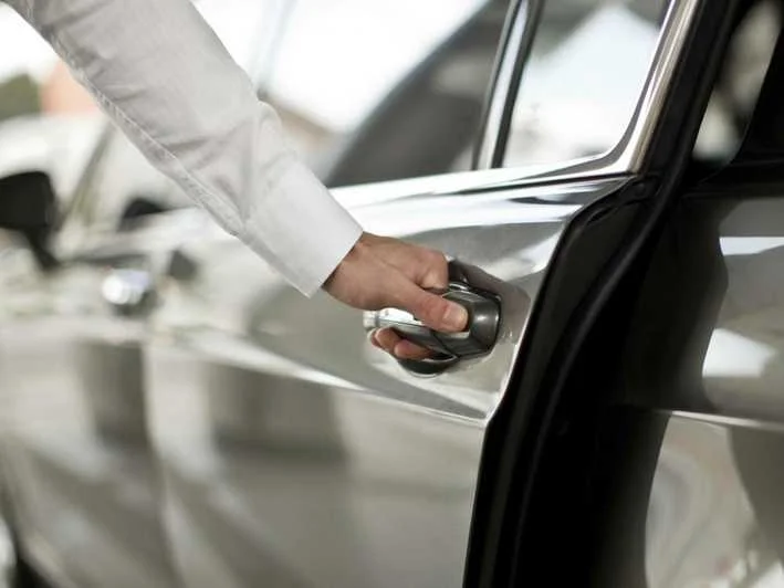 Persona usando control para abrir la puerta de un coche (mano en cerradura)