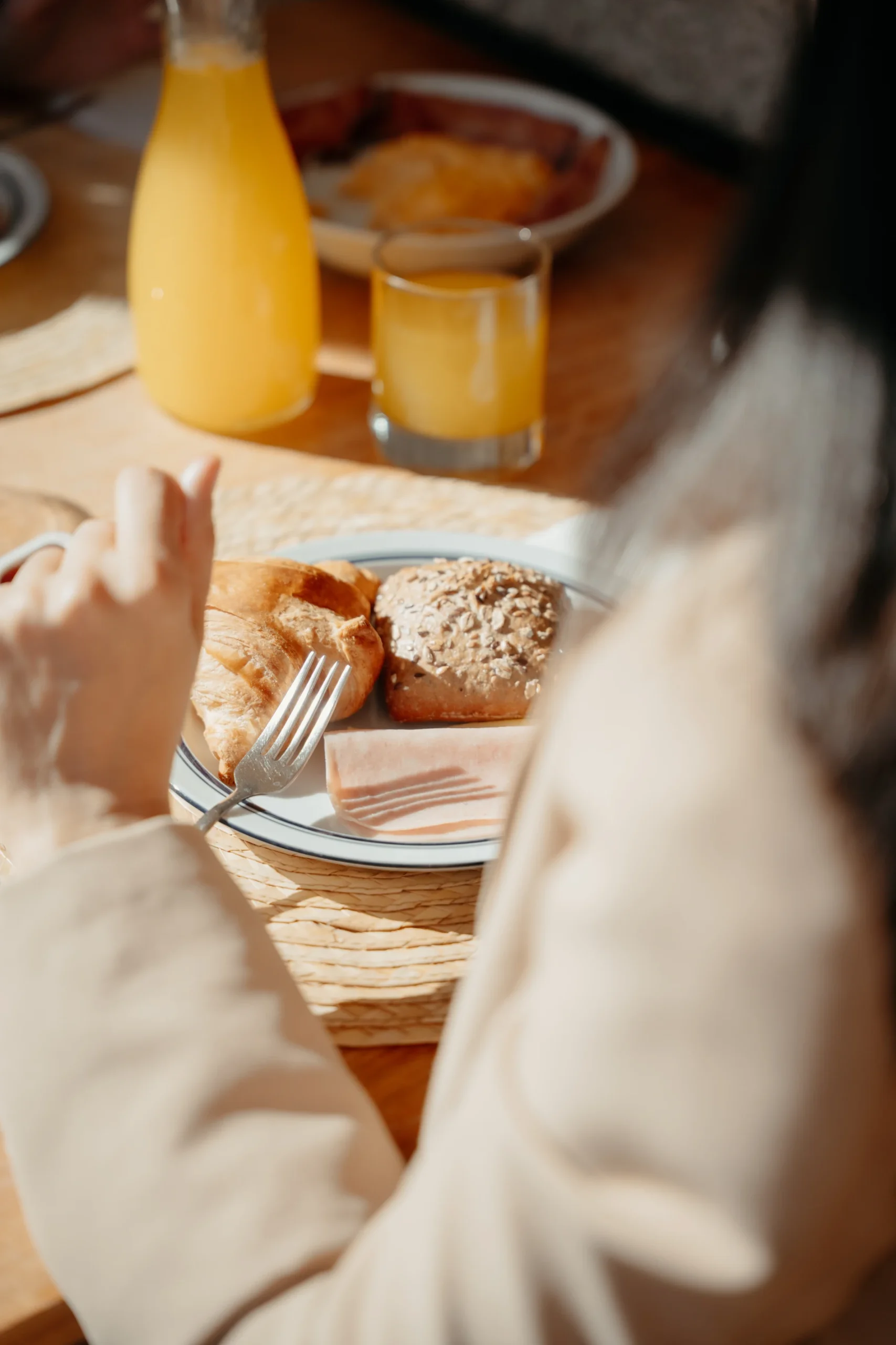 Café da manhã: pão e suco em mesa, com copo e garrafa amarelos