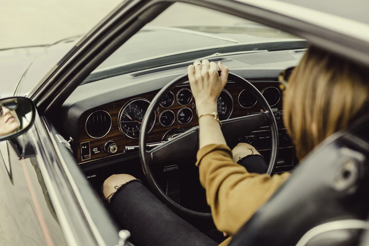 Motorista ao volante, m&atilde;o no volante em carro com painel detalhado