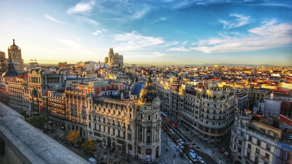 Panor&aacute;mica urbana de Madrid al atardecer, edificios y Gran V&iacute;a con cielo azul
