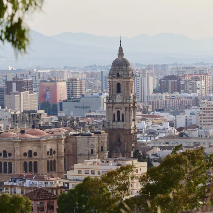 Vista de la ciudad con la c&uacute;pula de una iglesia y monta&ntilde;as al fondo