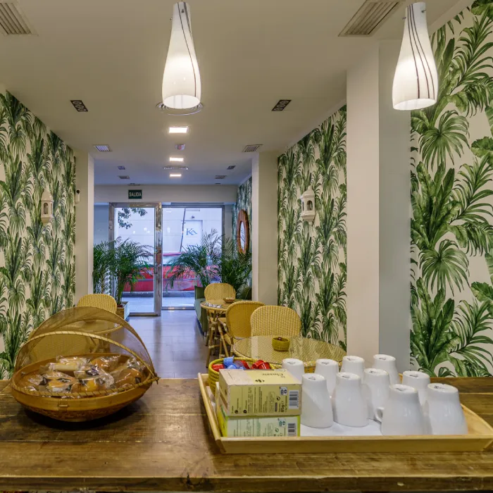Pasillo con decoraciones de hojas, mesas con botellas y asientos dorados