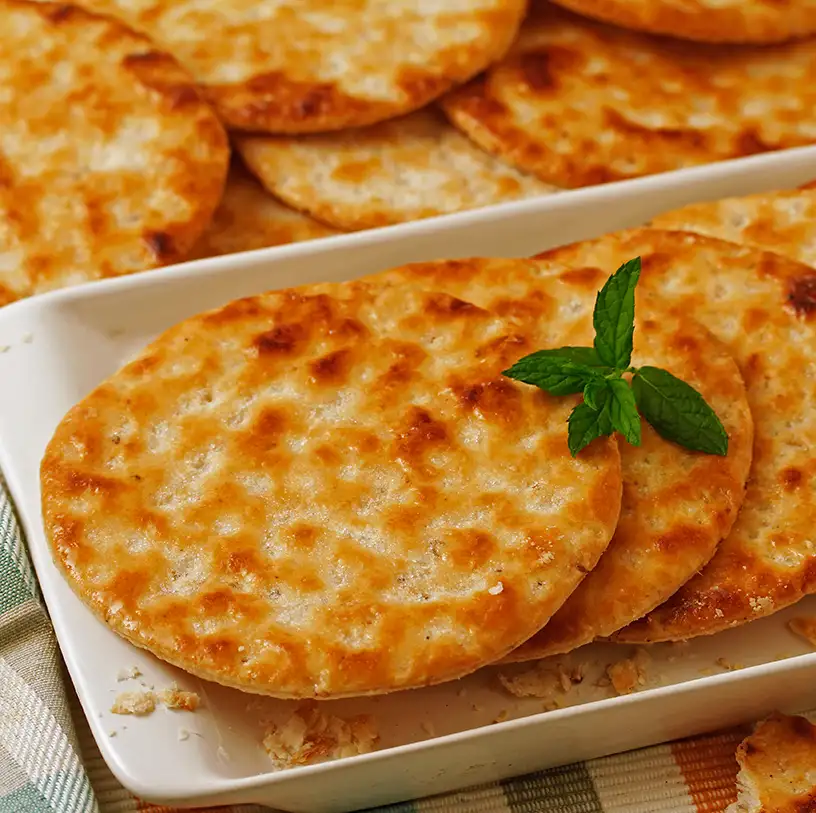 Tortillas de queso doradas con menta fresca en una fuente blanca