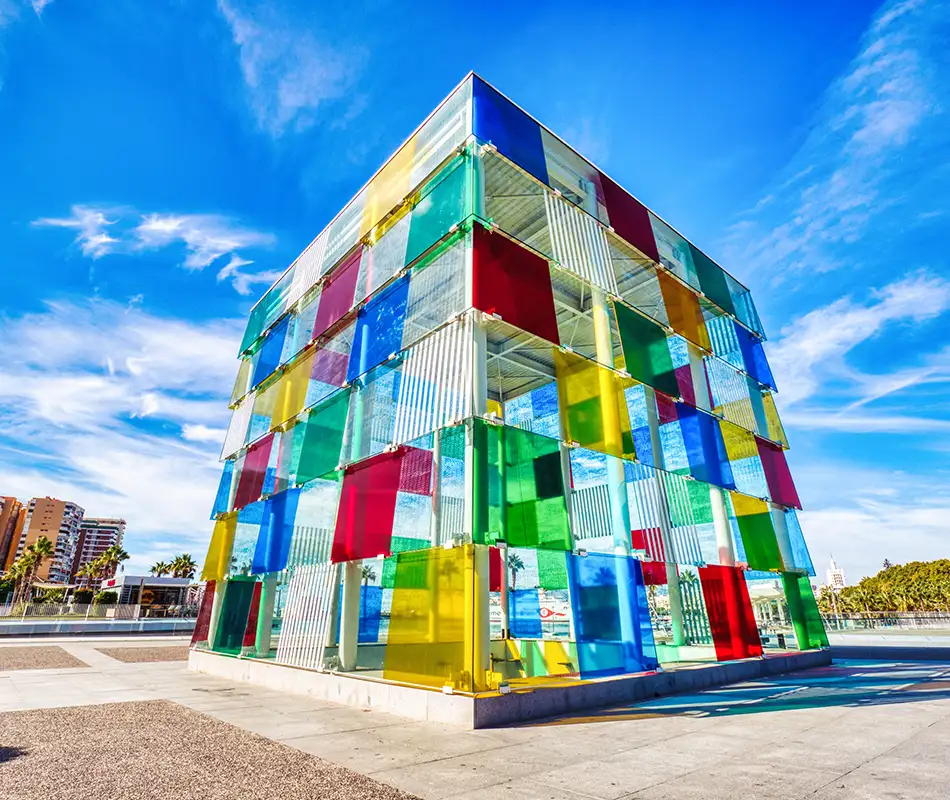 Fachada geom&eacute;trica de edificio con paneles de colores bajo cielo azul