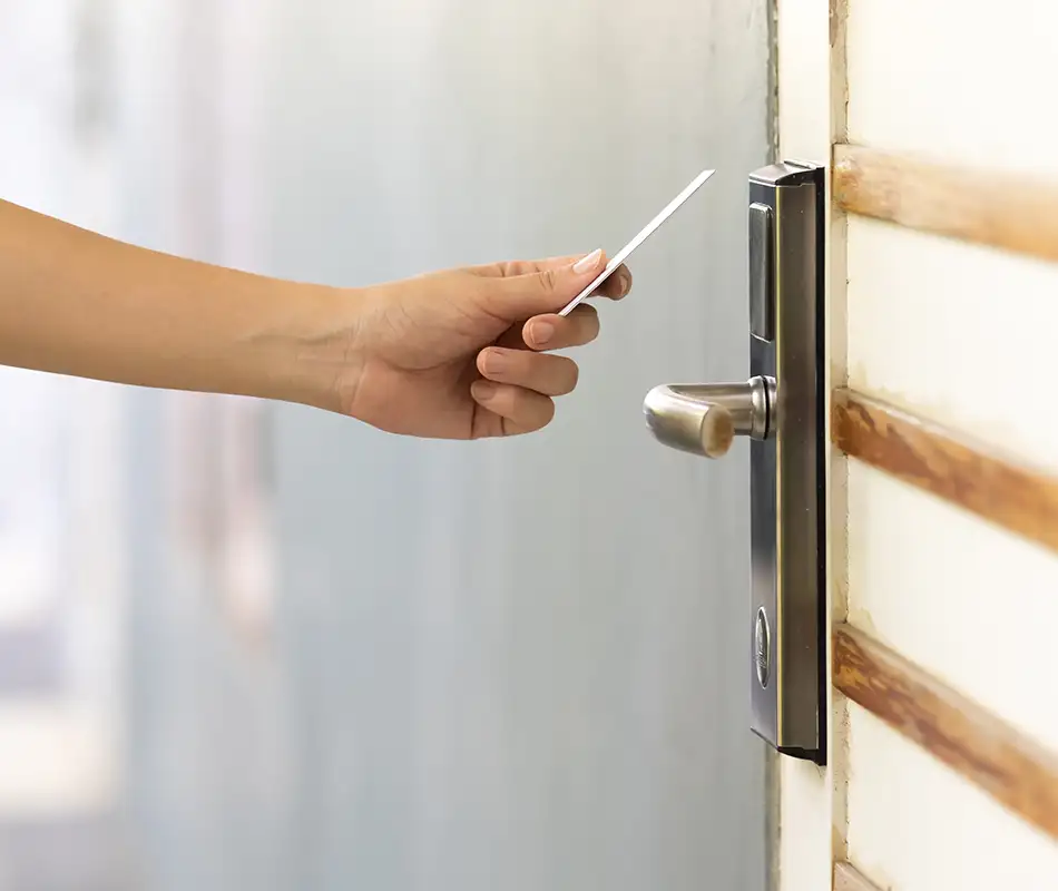 Persona abre una puerta con llave met&aacute;lica en una cerradura moderna