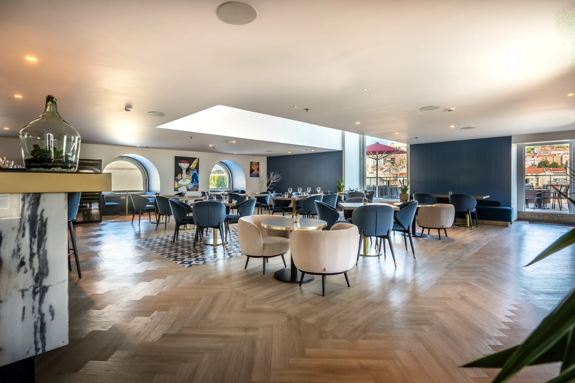 Sal&atilde;o de restaurante moderno com mesas, cadeiras e vista externa pela janela