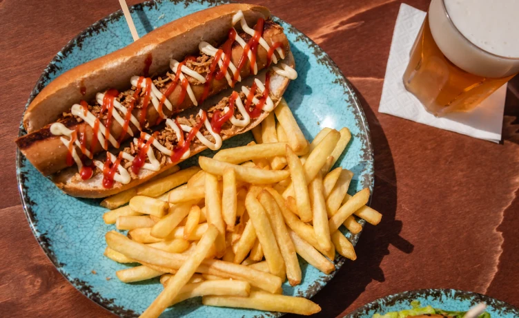 Dos hot dogs con tocino y mayonesa, acompa&ntilde;ados de papas fritas.