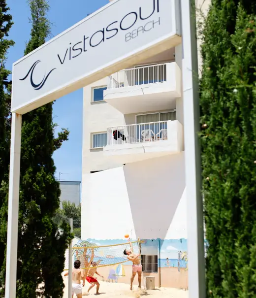Entrada del hotel Vistasol Beach con letrero y edificio blanco.