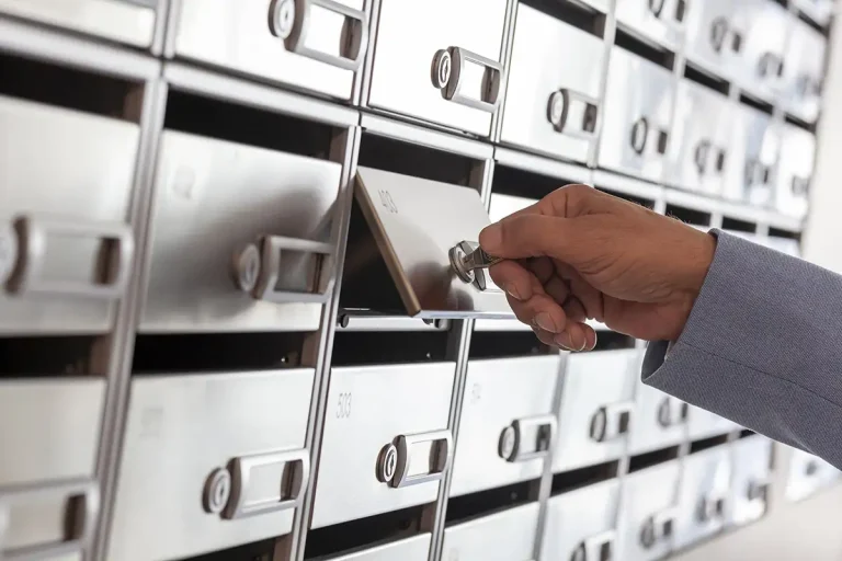 Mano abre un archivador met&aacute;lico con carpetas y cajones ordenados