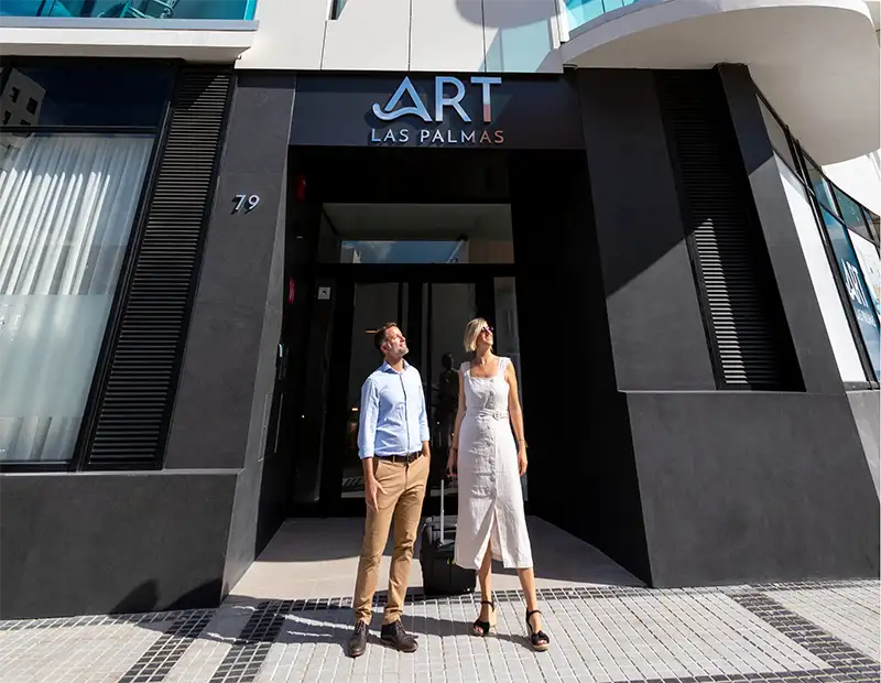 Entrada del hotel &ldquo;Art Las Palmas&rdquo; con dos personas caminando afuera