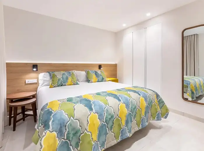 Dormitorio moderno con cama y edred&oacute;n estampado de mapa mundial