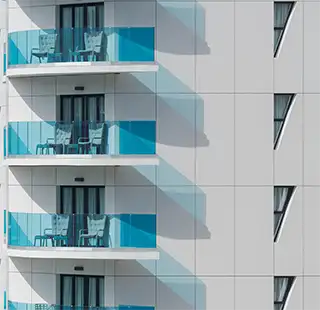 Balcones blancos con mesas y sillas en apartamentos modernos.