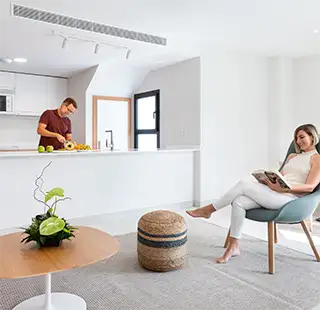 Hombre jugando con un juguete y mujer leyendo en sala moderna blanca