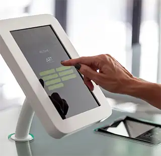 Persona tocando una pantalla de tablet en un quiosco interactivo
