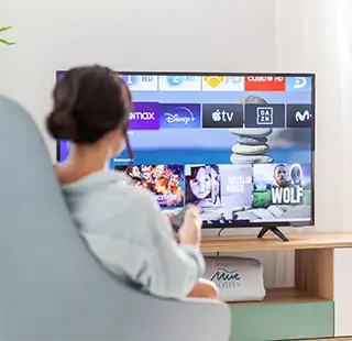 Persona viendo la TV con una pila de pel&iacute;culas y agua en pantalla