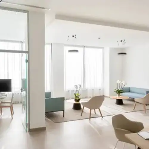 Interior moderno con sala de estar y ventanas grandes, mesa y sillas.