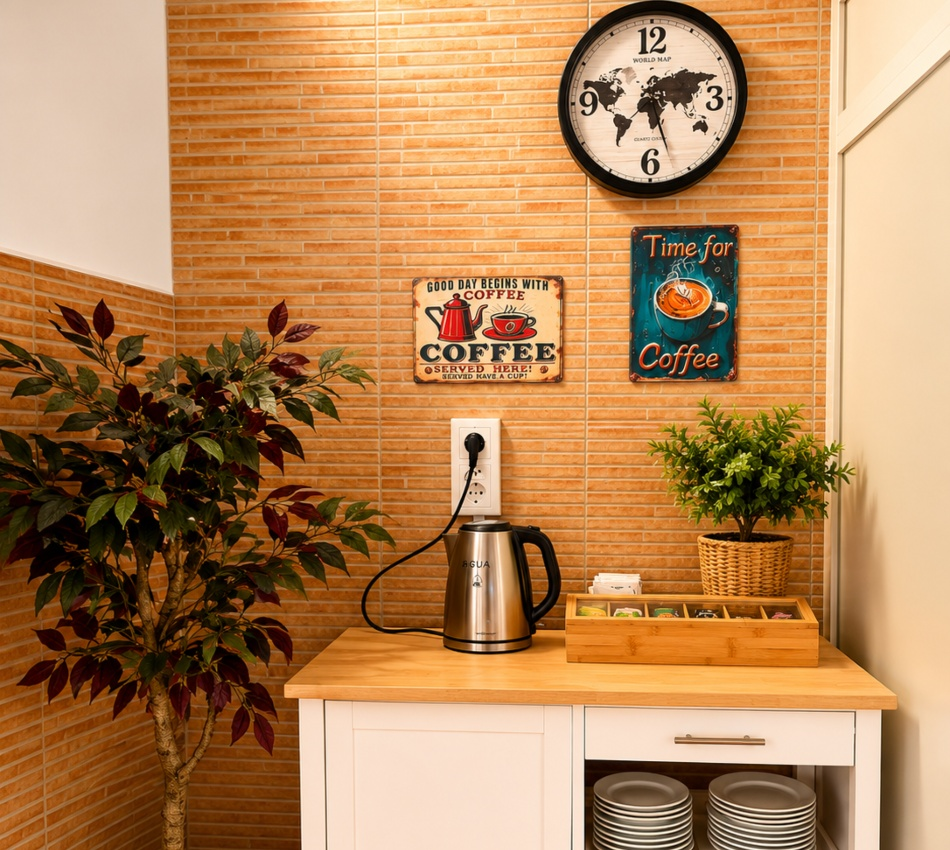 Reloj y carteles de caf&eacute; sobre encimera con cafetera el&eacute;ctrica en cocina.