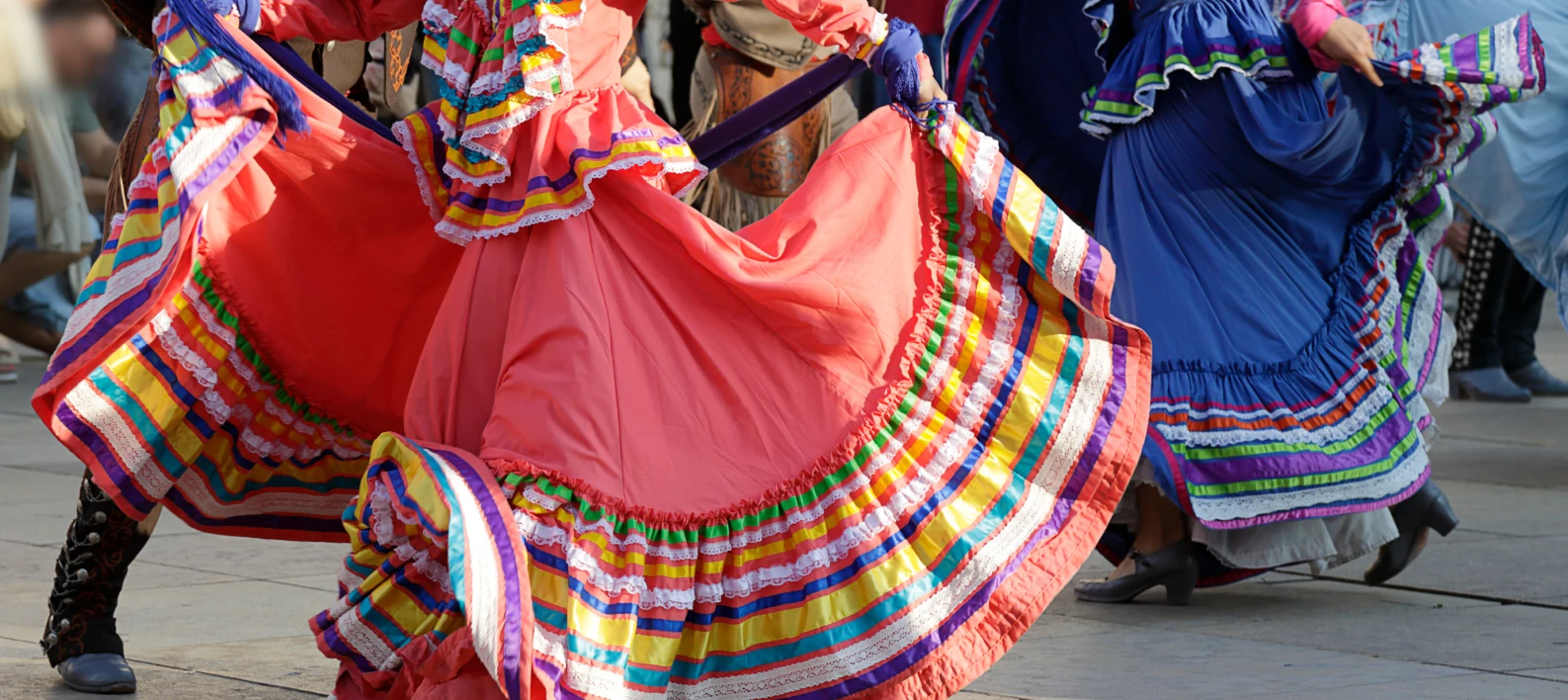 Bailarinas con faldas coloridas y cintas rojas y azules en un desfile cultural