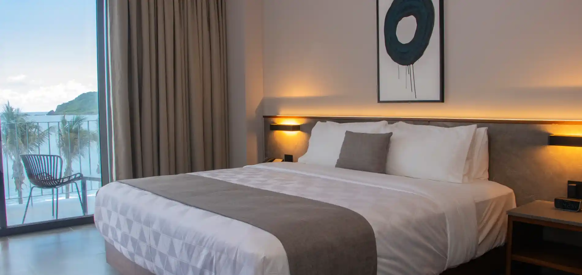 Habitaci&oacute;n de hotel moderna con cama y vista al atardecer
