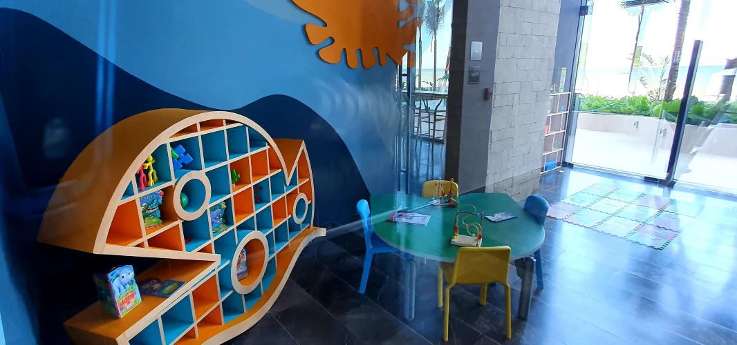 Sala infantil con mesa y estanter&iacute;a con forma de barco y letras O.