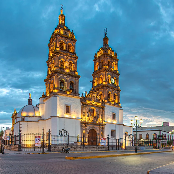 Catedral de estilo colonial con dos torres iluminadas al atardecer.