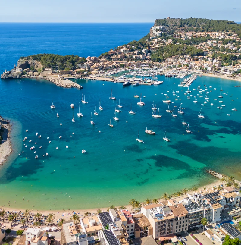 Vista a&eacute;rea de un puerto mediterr&aacute;neo con barcos, costa y casas junto al mar