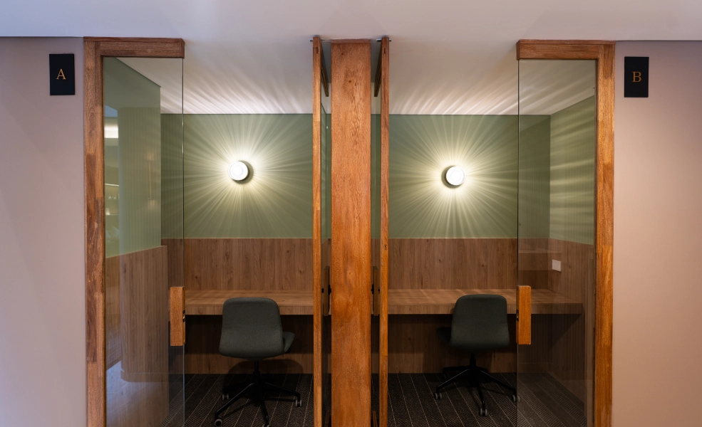 Despachos con puertas de madera, dos sillas y l&aacute;mparas de pared en el interior