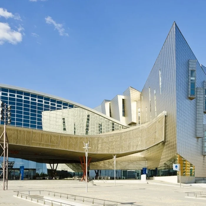 Edificios modernos con fachada de vidrio y cubierta curva bajo cielo azul