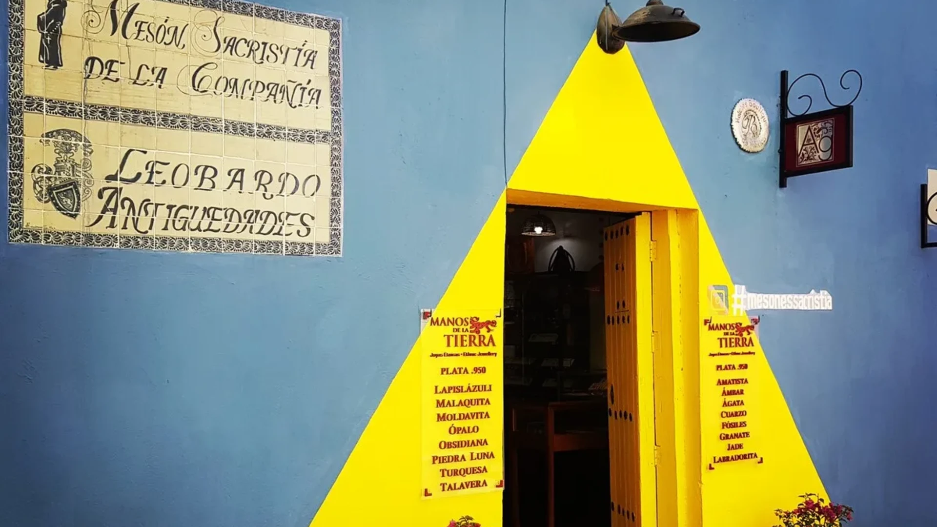 Pir&aacute;mide amarilla con puerta abierta y cartel de &ldquo;Manos de la Tierra&rdquo;
