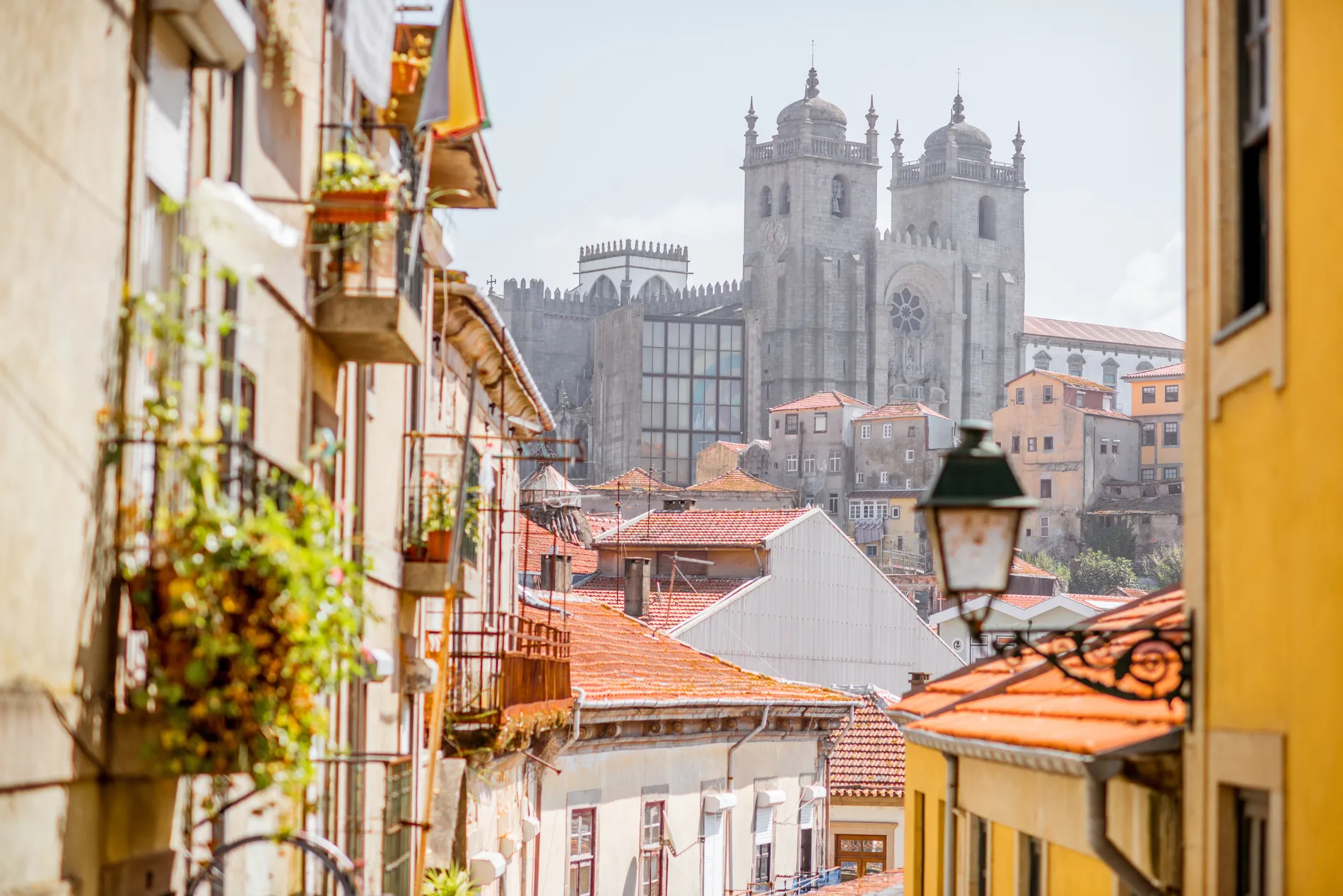 Catedral do Porto vista entre casas e bandeiras, com telhados ao fundo