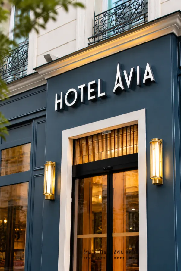 Fa&ccedil;ade de l&rsquo;Hotel Avia avec enseigne et entr&eacute;e vitr&eacute;e, lampes d&eacute;coratives