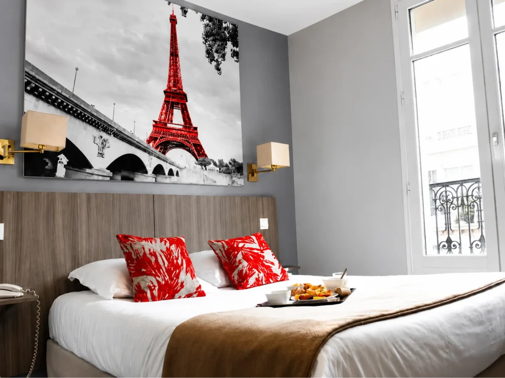 Chambre moderne avec coussins rouges et photo de la tour Eiffel sur le mur