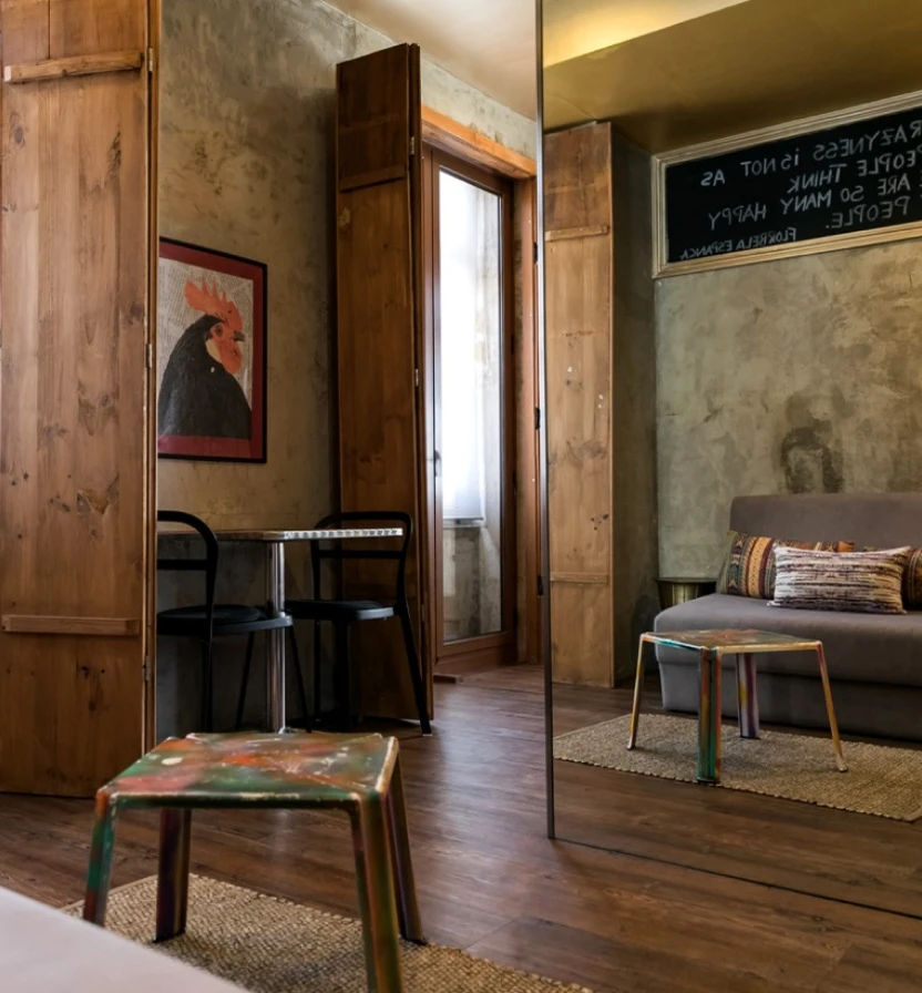 Cozy room with wooden walls, sofa, rug, and open door.
