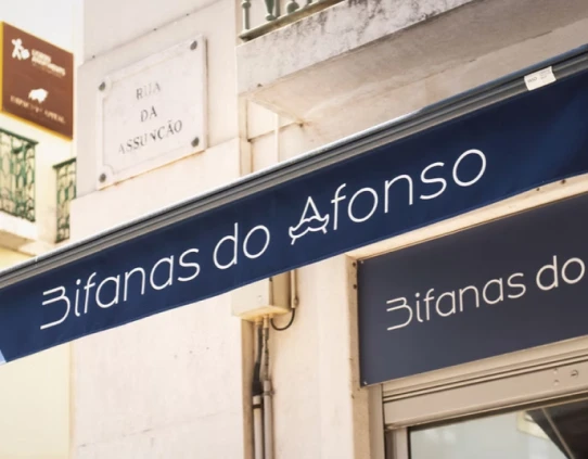 Street sign reading "3ifanas do Afonso" on a blue storefront awning.