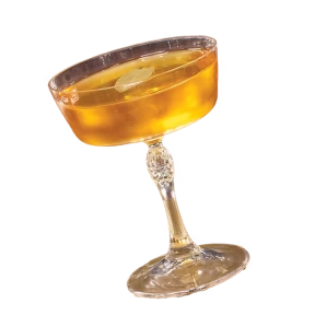 Golden amber cocktail with ice in a stemmed glass, isolated on black