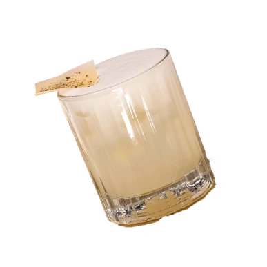 Glass mug with beige iced drink and ice cubes on a white background