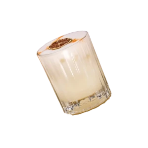 Tilted glass candle jar with label on black background