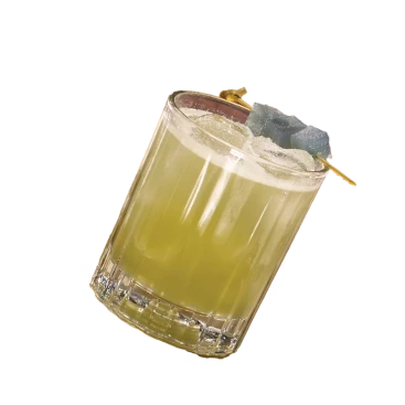 Glass of pale yellow drink with ice and a garnish, shot on black background