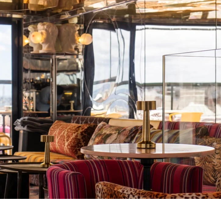 Stylish restaurant interior with colorful upholstered seats and round table.