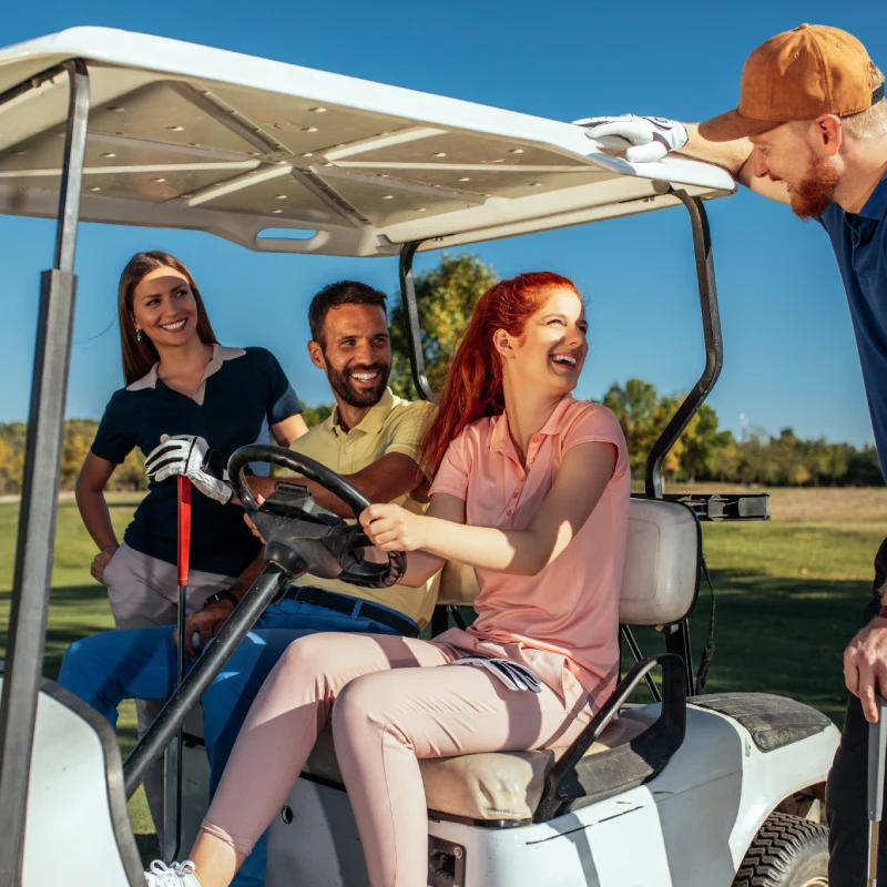 Personas conduciendo un carrito de golf al aire libre con sol