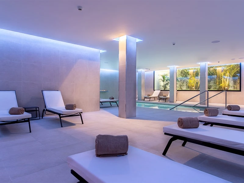 Terraza moderna con piscina, tumbonas y toallas al atardecer