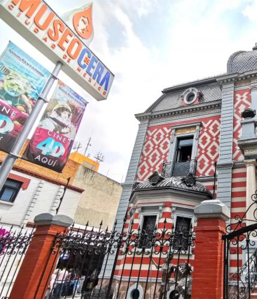 Fachada de edificio con letreros “Obra, LIQUIDO” y patrón rojo y blanco.