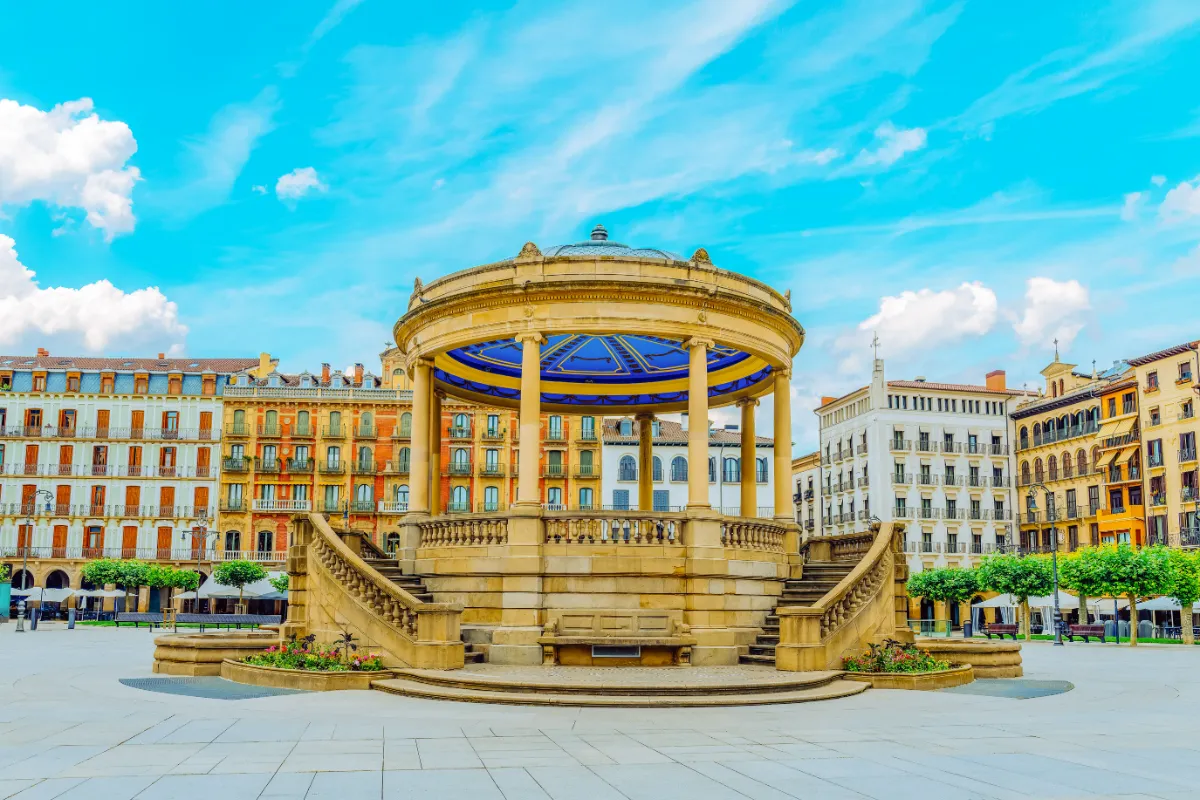 Fuente monumental en una plaza de ciudad, con edificios y cielo azul