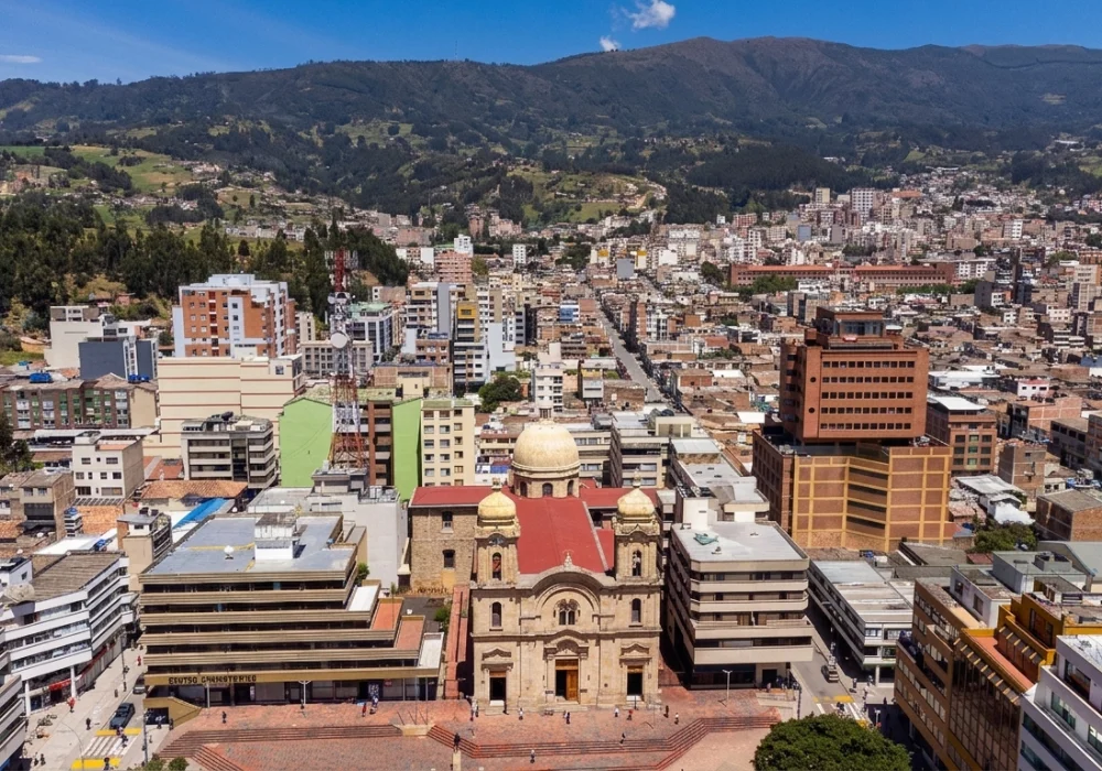 Vista a&eacute;rea de ciudad andina y una iglesia con c&uacute;pulas doradas en primer plano