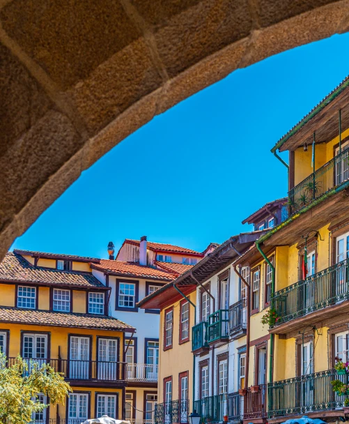 Casas coloridas com telhados e varandas sob c&eacute;u azul, visto do alto