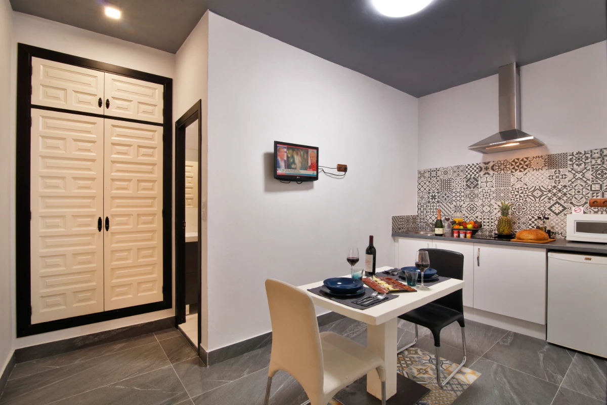 Cocina moderna con mesa, azulejos, campana extractora y puerta doble cerrada