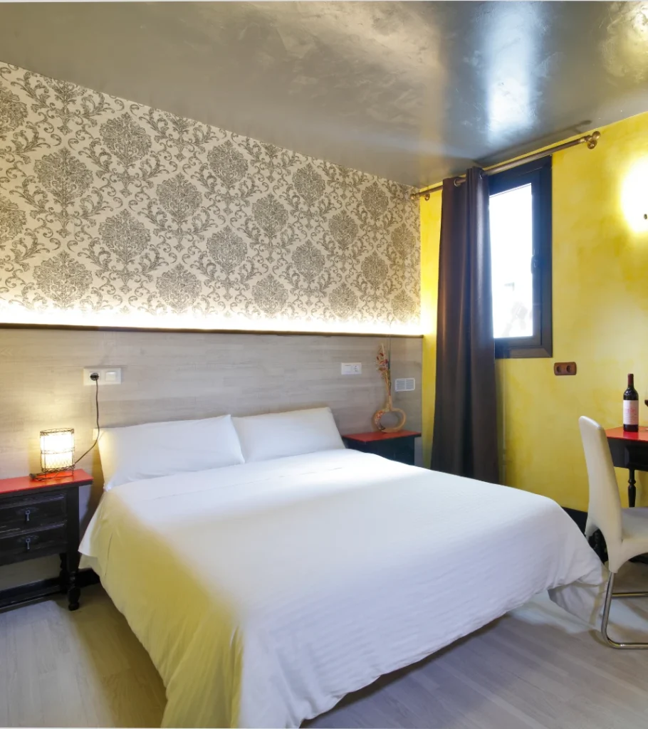Dormitorio moderno con cama doble, cortinas oscuras y paredes amarillas