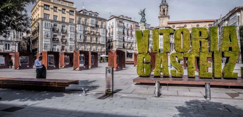 Plaza urbana con escultura grande de letras &ldquo;C&Aacute;DIZ&rdquo; y edificios hist&oacute;ricos.