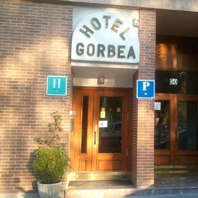Entrada del Hotel Gorbea con letrero y puerta de madera en ladrillo.