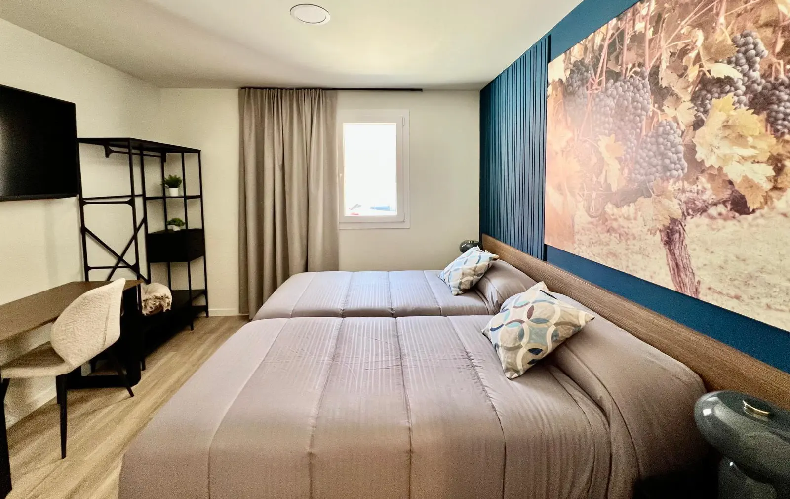 Dormitorio moderno con cama doble, cortinas beige y pared con arte mural